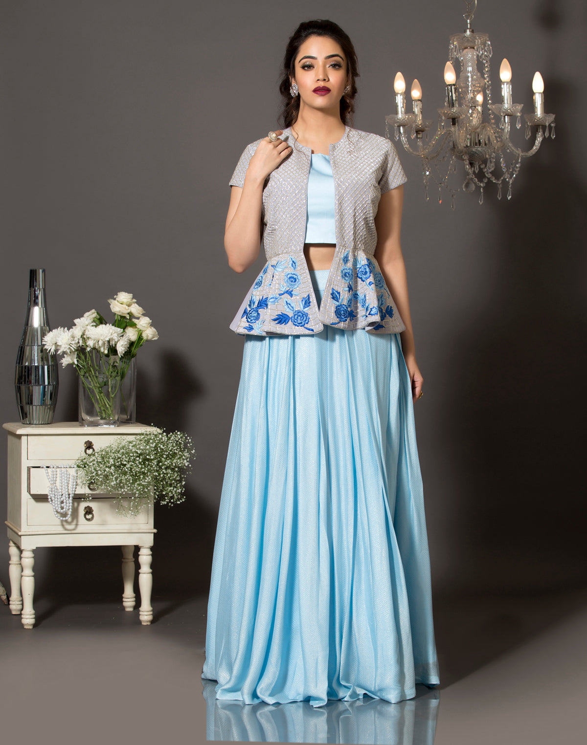 A sky blue shimmer lehenga set with pure crepe grey peplum jacket. The jacket is highlighted using silver cut-dana and the bottom with handcrafted resham embroidery.