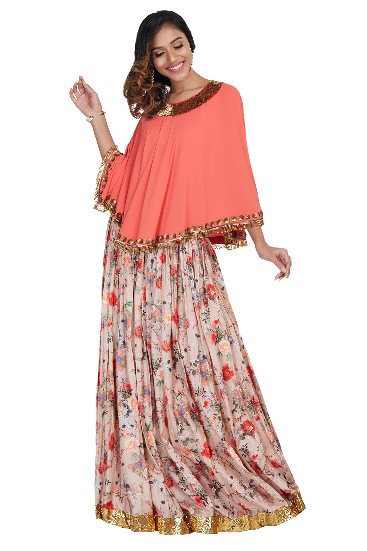 Going off-duty to an exotic destination? Don't leave without our peach cape tassled-blouse with bugle beads and complimenting floral printed skirt.
