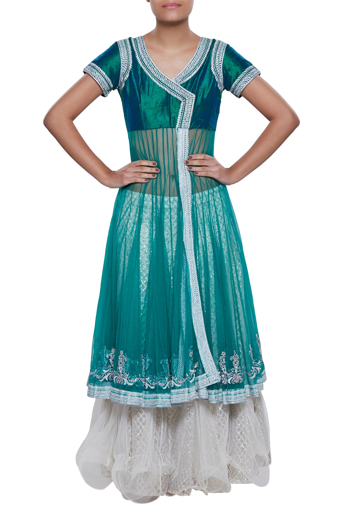 A twist to the traditional lehenga - take a leap with this piece that plays hide & seek in a part see-through and partly covered long net top with a gota border. The white skirt with ruffled edging keeps it classic.