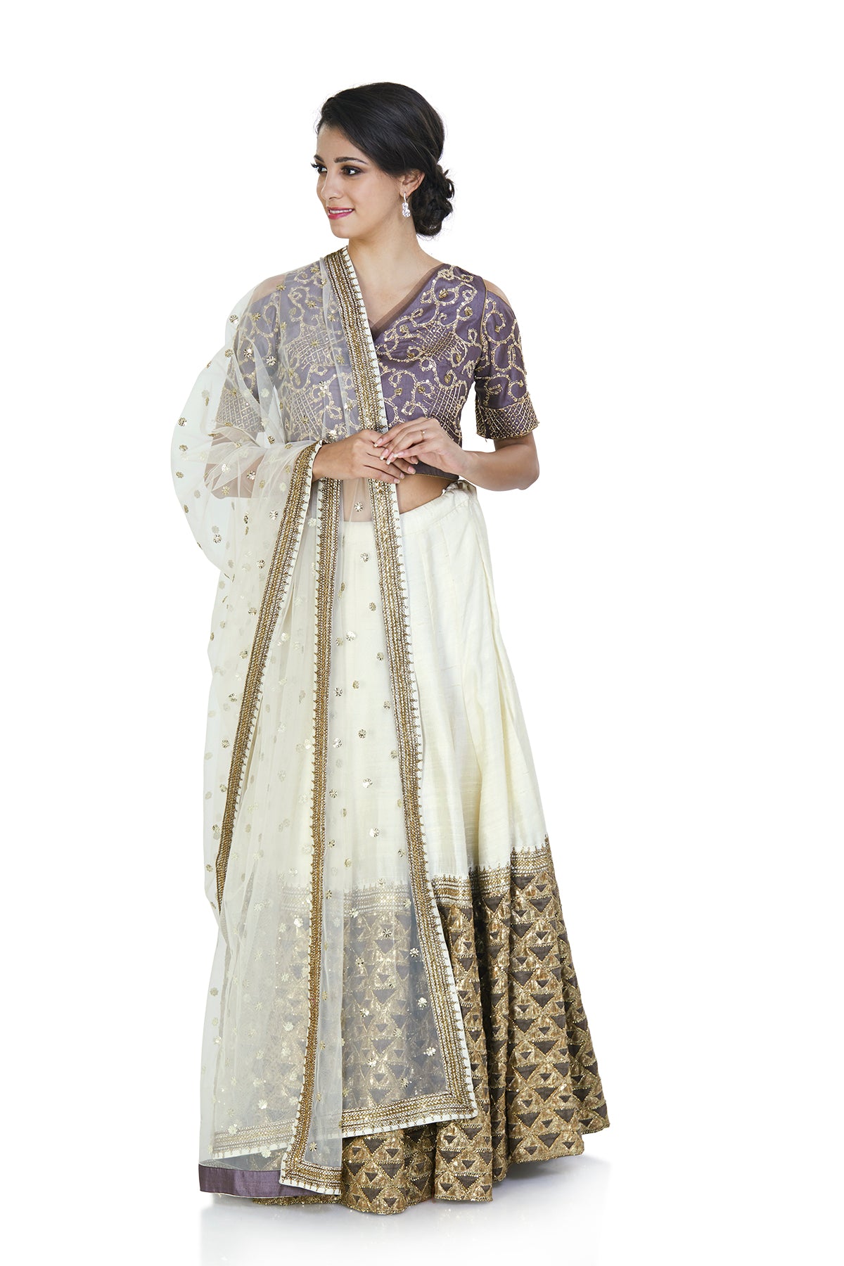 We bring some new edge to the vintage ivory silhouette with a capricious cut in this blouse worn over an ivory and grey lehenga embroidered with foil, bullion, and sequin. The outfit comes with a matching ivory dupatta.