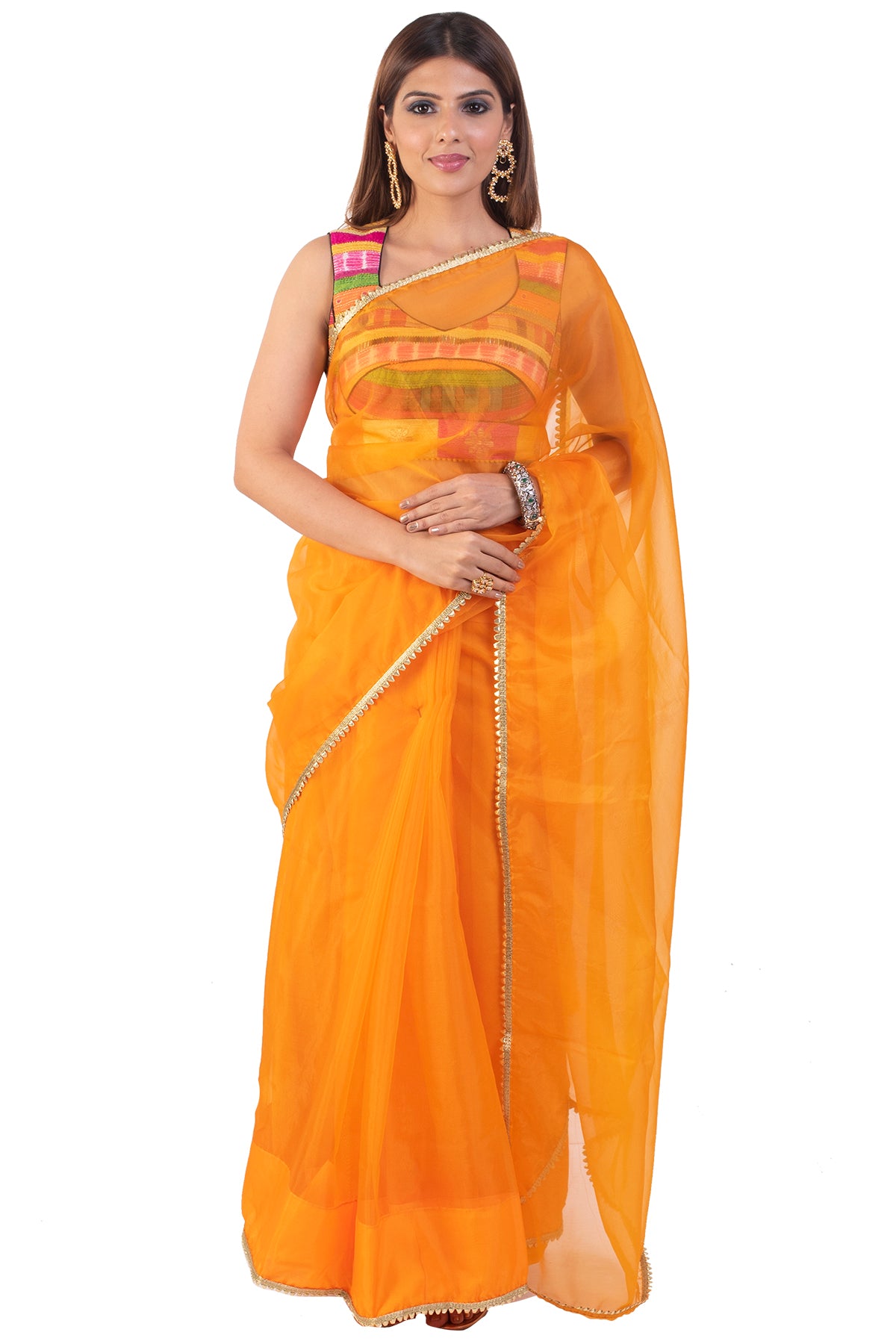There is nothing more engaging than colors, the sleeveless blouse that is an amalgamation of a range of colors paired with a plain orange saree is the elephant in the room!