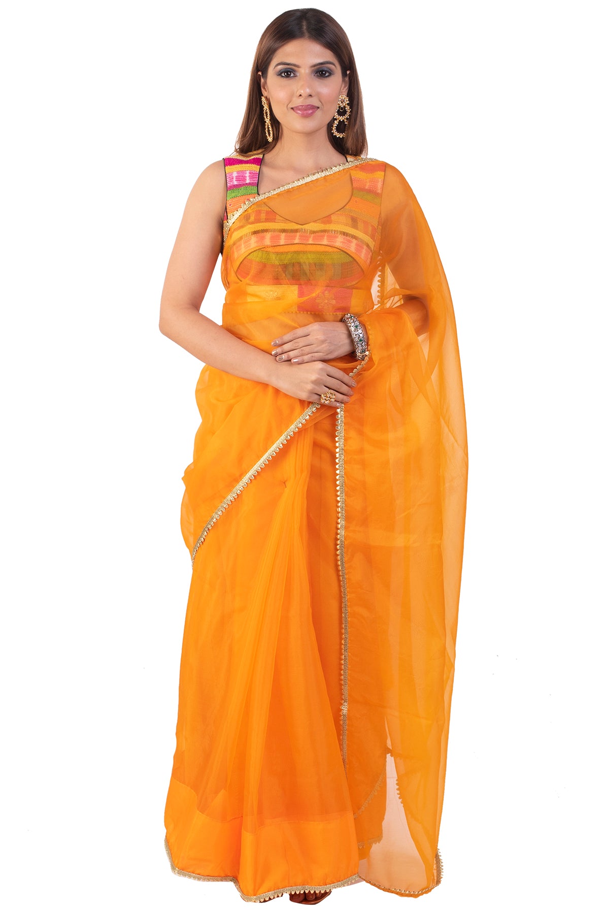 There is nothing more engaging than colors, the sleeveless blouse that is an amalgamation of a range of colors paired with a plain orange saree is the elephant in the room!