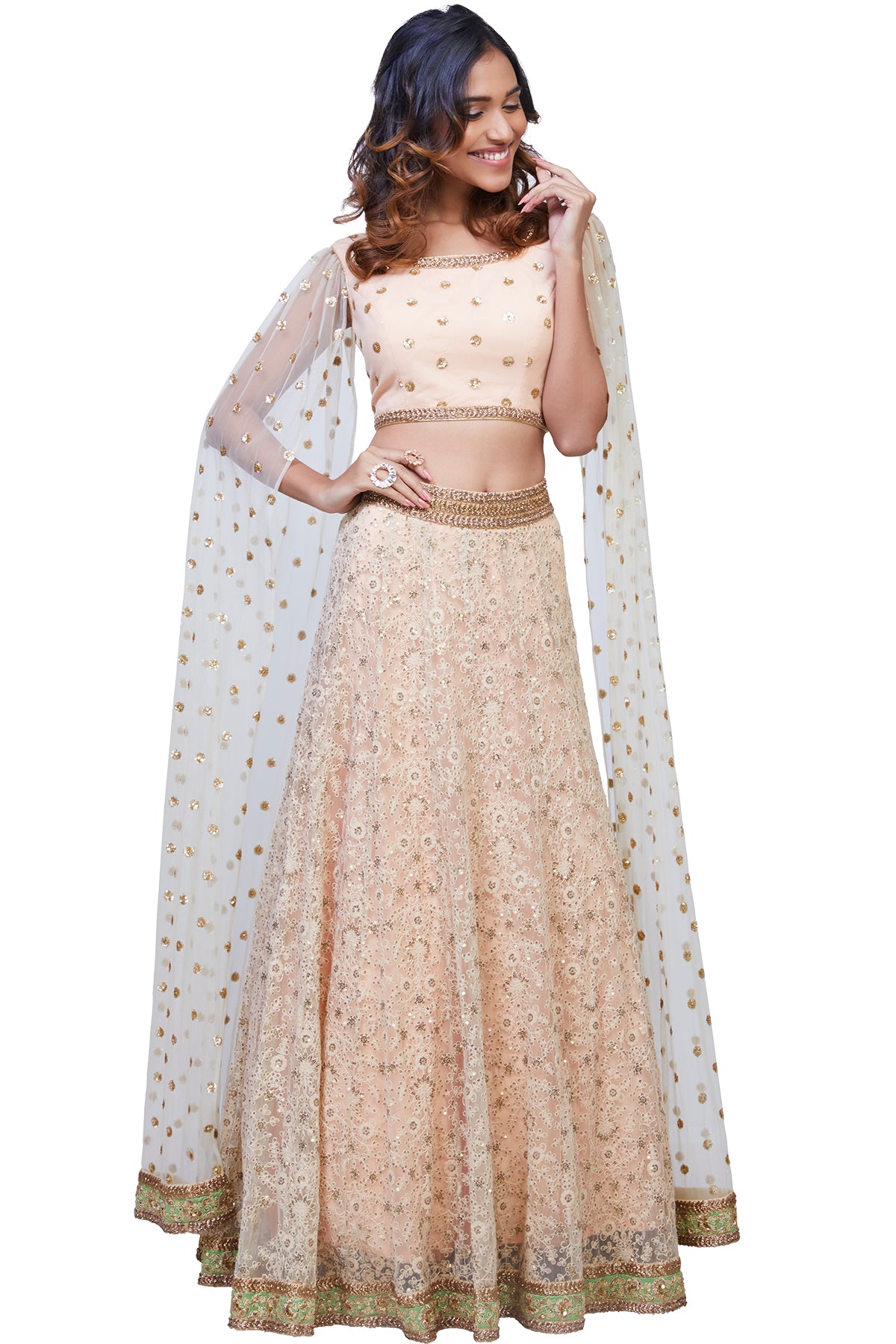 Flutter with finesse in this peach and white net lehenga with thread and sequins embroidery paired with a floor-length cape sleeves blouse.